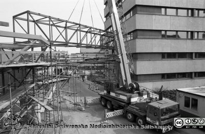 Bryggan mellan centralblocket och onkologiska kliniken sätts upp 1988-04-29
Lasarettsfotograferna i Lund.  Blandade negativ, omärkta år 1988-1995 (lösa negativhållare). Bryggan mellan centralblocket och onkologiska kliniken sätts upp 1988-04-29. Den kom aldrig till avsedda användning, för det blev aldrig någon onkologisk avdelning i centralblocket. Från negativ.
Nyckelord: Lasarettet;Lund;Universitetssjukhuset;USiL;vergång;Brygga;Onkologiska;Kliniken;Centralblocket