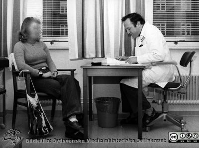 Docent Bo Ursing med en patient på infektionskliniken i Lund
Foto ur ett album tillägnat professor Karl Emil Thulin på hans 60-årsdag, 1975. 
Nyckelord: Lasarettet;Lund;Universitetssjukhuset;USiL;Infektion;Kliniken;Epidemiologiska;Mottagning