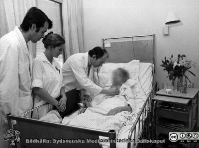 Undersökning bedside på infektionskliniken i Lund ~1975
Foto ur album tillägnat professor Karl Emil Thulin på hans 60-årsdag, 1975. Undersökning av sängliggande patient. Från vänster dr. Tony Edén, en sjuksköterska och docent Sven-Åke Hedström.
Nyckelord: Lasarettet;Lund;Universitetssjukhuset;USiL;Undersökning;Epidemiologiska;Kliniken;Infektion