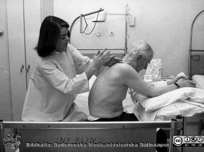 Sjukgymnast behandlar andningsproblem c:a 1975
Album till Karl Emil Thulins 60-årsdag, 1975. En sjukgymnast på en av infektionsklinikens vårdavdelningar bankar en patient med lung- och andningsproblem på ryggen.
Nyckelord: Lasarettet;Lund;Universitetssjukhuset;USiL;Infektion;Epidemiologiska;Kliniken