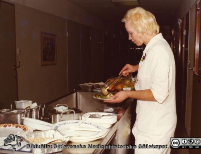 Mat delas ut på infektionskliniken i Lund ~1975
Foto ur album tillägnat professor Karl Emil Thulin på hans 60-årsdag, 1975. Ett biträde eller en undersköterska Ingeborg portionerar upp mat till de sängliggande patienterna på infektionskliniken i Lund.
Nyckelord: Lasarettet;Lund;Universitetssjukhuset;USiL;Infektion;Kliniken;Epidemiologiska