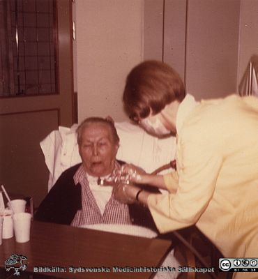 Tracheostomerad man på infektionskliniken i Lund 
Karl Emil Thulins efterlämnade fotoalbum. 1970-talet, i infektionsklinikens bibliotek. Från originalfoto.
Nyckelord: Lasarettet;Lund;Universitetssjukhuset;USiL;Epidemi;Installation;Kliniken