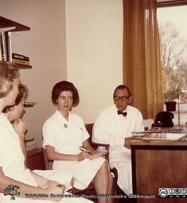  Professor Karl-Emil Thulin på s.k. sittrond i expeditionen på avdelning 81. 
Karl Emil Thulins efterlämnade fotoalbum. 1970-talet, i infektionsklinikens bibliotek. Avdelningsföreståndaren Angela Magnusson sitter närmast professor Karl-Emil Thulin. Från originalfoto.
Nyckelord: Lasarettet;Lund;Universitetssjukhuset;USiL;Epidemi;Installation;Kliniken