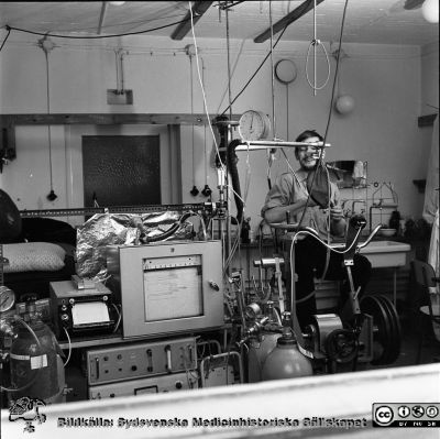 Laboratorieuppställning för arbetsprov med spirometri på ergometercykel. 
Bilder från Olle Hammar, fysiologiska instittutionen i Lund. Laboratorieuppställning för arbetsprov med spirometri på ergometercykel. Negativblad märkt "D.T. 12/3-69".
