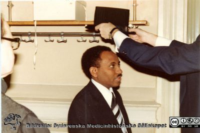 Experimentell hjärnforskning i Lund. Doktoranden och neurokirurgen Ali Abdul Rahman kreeras till doktor vid en urtima ceremoni
Neurokirurgen Dr Ali Abdul Rahman från Sudan promoveras vid en urtima promotion i februari 1980 i anatomiska institutionens atrium/trapphall. Promotor var fakultetens dekanus, Håkan Westling Han blev samtidigt specialistkompetent i neurokirurgi.
