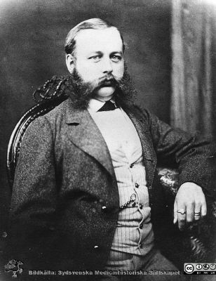 Gadde, Nils Olof Anders Ohlsson.
Kirurgen Lund. Disputationsfoton. Pärm nr 1.  Född i Lund 9/6/1834. Student i Lund 1851. Filos. Kand. 1861. Med. Lic. 1864. Med.Dr. 1865. Lärare vid undervisningsanstalten för barnmorskor i Lund 1864-1900. Förste läkare vid in värtesavdelningen av Malmhus läns sjukvårdsinrättningar i Lund samt sjukhusdirektör där 1868-1899. Erhöll 1886 professors namn, heder och värdighet.
Död 7/4 1904." Reprofoto.
Nyckelord: Lasarettet;Lund;Universitetssjukhuset;Universitetssjukhuset;Kirurgiska;kliniken