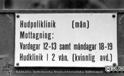 Skylt på dåvarande hudkliniken i Lund
Ur yrkesdermatologen Sigfrid Fregerts bildsamling från hud- och könskliniken i Lund och från yrkesdermatologiska avdelningen i Lund. Skylt om poliklinik (män) och hudklinik I (kvinnor, på våning 2) på hudkliniken. Skylten bör ha suttit innanför huvudentrén. Foto.
Nyckelord: Lasarettet;Lund;Universitetssjukhuset;USiL;Hud- och könsklinik;Dermatologisk;Venerologisk