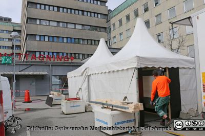 Covidpandemin. Förtält sätts i mars 2020 upp framför akutmottagningen på SUS i Lund
I början på Covid-19-pandemin satte man i mars 2020 upp tält framför olika ingångar på Universitetssjukhuset SUS i Lund. Vilden visar tältet framför akutmottagningen.Bildkälla: Informarionsavdelningen SUS. Tälten fanns kvar olika länge. Detta  togs ned i slutet av året.
Nyckelord: Pandemi;Covid-19;Universitetssjukhus;SUS i Lund;Epidemi;Akutmottagning;Förtält