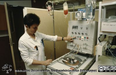 Blodcentrifug på Blodcentralen i Lund
Ur låda med blandade diabilder från sjukhusfotograferna i Lund, 1970-, 1980- och 1990-talen. Bild utan beskrivning. BMA Ann-Margreth Swärd-Nilsson på Blodcentralen i Lund vid en centrifug för kontinuerlig blodseparation.
Nyckelord: Lasarettet;Lund;Universitetssjukhuset;USiL;Blod;Hämatokrit;Separation;Blodprodukt