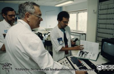 Docent Eric Lindstedt vid installationen av litotriptorn på urologiska kliniken
Docent Eric Lindstedt vid installationen av litotriptorn på urologiska kliniken i Lund 1988. Tekniker från leverantören eller avdelningen för medicinsk teknik i bakgrunden.
Nyckelord: Urologisk;Klinik;Universitetssjukhuset i Lund;USiL;Stenkross;Litotriptor