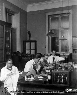 1928 års kurs i histologi i Lund
Fotoalbum märkt Histologikursen anno 1928. 
Detta album innehåller bilder från dåvarande histologiska avdelningen på anatomiska institutionen i Lund på Biskopsgatan 7. Liksom de övriga i serien skapades det av kursdeltagarna och tillägnades kursledaren, professor Torsten Hellman, som uppskattning av hans lärargärning. Bildtext nedanför: "Jocknick, Linderoth, Widerborg, Arvidsson". Kanske tillverkning av preparat på objektglas för mikroskopiering. 
Bildkälla Stiftelsen Locus Medicus Lundensis 250317.
Nyckelord: Locus Medicus Lundensis;Medicinska fakulteten i Lund;Histologiska avdelningen;Sydsvenska Medicinhistoriska Sällskapet;SMHS;Anatomiska Institutionen;Studenter