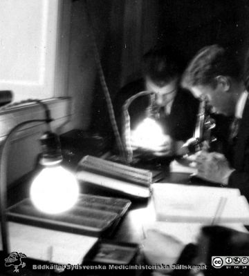 1928 års kurs i histologi i Lund
Fotoalbum märkt Histologikursen anno 1928. 
Detta album innehåller bilder från dåvarande histologiska avdelningen på anatomiska institutionen i Lund på Biskopsgatan 7. Liksom de övriga i serien skapades det av kursdeltagarna och tillägnades kursledaren professor Torsten Hellman som uppskattning av hans lärargärning. Bildtext "Inge Gjötlén". En okänd elev i bakgrunden. Studenter vid kursmikroskop och preparatlådor.
Bildkälla Stiftelsen Locus Medicus Lundensis 250317.
Nyckelord: Locus Medicus Lundensis;Medicinska fakulteten i Lund;Histologiska avdelningen;Sydsvenska Medicinhistoriska Sällskapet;SMHS;Anatomiska Institutionen;Studenter