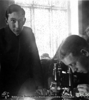 1928 års kurs i histologi i Lund
Fotoalbum märkt Histologikursen anno 1928. 
Detta album innehåller bilder från dåvarande histologiska avdelningen på anatomiska institutionen i Lund på Biskopsgatan 7. Liksom de övriga i serien skapades det av kursdeltagarna och tillägnades kursledaren professor Torsten Hellman som uppskattning av hans lärargärning. Bildtext nedanför: "af Jocknick, Arne Sundholm. Studenter vid kursmikroskop.
Bildkälla Stiftelsen Locus Medicus Lundensis 250317.
Nyckelord: Locus Medicus Lundensis;Medicinska fakulteten i Lund;Histologiska avdelningen;Sydsvenska Medicinhistoriska Sällskapet;SMHS;Anatomiska Institutionen;Studenter;Lärare