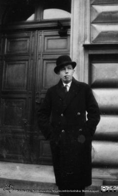 1928 års kurs i histologi i Lund
Fotoalbum märkt Histologikursen anno 1928. 
Detta album innehåller bilder från dåvarande histologiska avdelningen på anatomiska institutionen i Lund på Biskopsgatan 7. Liksom de övriga i serien skapades det av kursdeltagarna och tillägnades kursledaren, professor Torsten Hellman, som uppskattning av hans lärargärning. Bildtext  "Göran Gerner". Foto utanför ingången till anatomiska institutionen.
Bildkälla Stiftelsen Locus Medicus Lundensis 250317.
Nyckelord: Locus Medicus Lundensis;Medicinska fakulteten i Lund;Histologiska avdelningen;Sydsvenska Medicinhistoriska Sällskapet;SMHS;Anatomiska Institutionen;Studenter