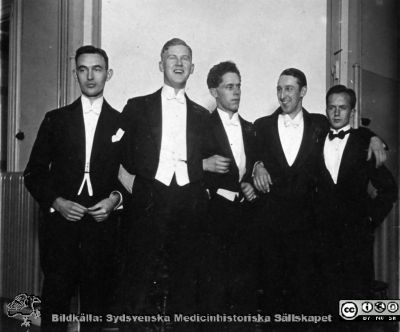 1928 års kurs i histologi i Lund
Fotoalbum märkt Histologikursen anno 1928. 
Detta album innehåller bilder från dåvarande histologiska avdelningen på anatomiska institutionen i Lund på Biskopsgatan 7. Liksom de övriga i serien skapades det av kursdeltagarna och tillägnades kursledaren professor Torsten Hellman som uppskattning av hans lärargärning. Bildtext saknas. Fem studenter i akademisk högtidsdräkt, frack.  Foto kanske i en av föreläsningssalarna på institutionen. Nr 2 från vänster kan vara amanuensen Hjalmar Sjövall. 
Bildkälla Stiftelsen Locus Medicus Lundensis 250317.
Nyckelord: Locus Medicus Lundensis;Medicinska fakulteten i Lund;Histologiska avdelningen;Sydsvenska Medicinhistoriska Sällskapet;SMHS;Anatomiska Institutionen;Studenter;Lärare;Fest