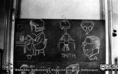 1928 års kurs i histologi i Lund
Fotoalbum märkt Histologikursen anno 1928. 
Detta album innehåller bilder från dåvarande histologiska avdelningen på anatomiska institutionen i Lund på Biskopsgatan 7. Liksom de övriga i serien skapades det av kursdeltagarna och tillägnades kursledaren professor Torsten Hellman som uppskattning av hans lärargärning. Bildtext  saknas. Karikatyrer uppritade på svarta tavlan av en god men okänd tecknare. Kanske institutionspersonal, kanske kursmedlemmar. "BATTA" står möjligen för Berta Zander-Olsson. "GA" betyder nog Gustav-Adolof Landoff. Jämför med siluetten i bildfil imgLA2250318ff142.  
Bildkälla Stiftelsen Locus Medicus Lundensis 250317.
Nyckelord: Locus Medicus Lundensis;Medicinska fakulteten i Lund;Histologiska avdelningen;Sydsvenska Medicinhistoriska Sällskapet;SMHS;Anatomiska Institutionen;Studenter;Lärare