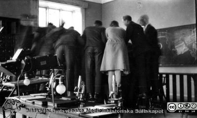 Fotoalbum tillägnat Professor Torsten Hellman 1929.
Fotoalbum tillägnat Professor Torsten Hellman med tacksamhet och vördnad från histologikursen 1929. Bildtext "Slutet gott allting gott". Rimligen medicine studeranden på histologiska avdelningens mikroskoperingssal mot slutet av kursen.. 
Bildkälla Stiftelsen Locus Medicus Lundensis 250317. Fotograf okänd.
Nyckelord: Anatomiska Institutionen;Histologiska avdelningen;Medicine studerande;Locus Medicus Lundensis;Medicinska fakulteten i Lund;Mikroskoperingssal