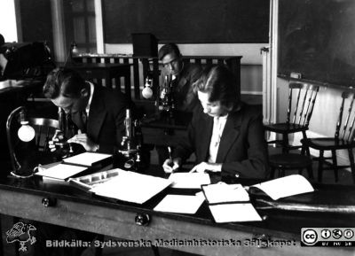 Fotoalbum från histologikursen i Lund 1931
Fotoalbum från histologikursen 1931. Bildtext "Arbete och - -". Foto troligen i histologiska avdelningens föreläsningssal på anatomiska institutionen i Lund. Lyssna, anteckna och memorera!
Bildkälla Stiftelsen Locus Medicus Lundensis 250317. Sydsvenska Medicinhistoriska Sällskapet / SMHS. Fotograf okänd.
Nyckelord: Medicine studerande;Histologiska avdelningen;Anatomiska Institutionen;Medicinska fakulteten i Lund;Locus Medicus Lundensis;Universitetet i Lund;Föreläsningssal