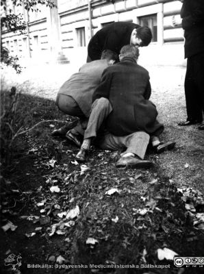 Fotoalbum  från histologkursen 1931.  Bildtext "Det stora anfallet, men vart tog han vägen?". "Barnens" ystra lekar i anatomiska insitutionens park. Löven har börjat falla. 
Bildkälla Stiftelsen Locus Medicus Lundensis 250317. Sydsvenska Medicinhistoriska Sällskapet / SMHS. Fotograf okänd.
Nyckelord: Medicine studerande;Histologiska avdelningen;Anatomiska Institutionen;Medicinska fakulteten i Lund;Locus Medicus Lundensis;Universitetet i Lund;Studenterna leker i parken