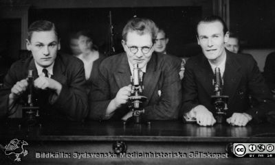 Fotoalbum "Kursen i histologi H T 1932.
Fotoalbum "Kursen i histologi H T 1932". Bildtext "Hässler, Thornell, Hallberg".  Troligen tre medicine studerande vid  kursmikroskop på histologiska avdelningens mkroskoperingssal på anatomiska institutionen i Lund. 
Bildkälla stiftelsen Locus Medicus Lundensis och Sydsvenska Medicinhistoriska Sällskapet / SMHS. Fotograf okänd.
Nyckelord: Medicine studerande;Histologiska avdelningen;Anatomiska Institutionen;Medicinska fakulteten i Lund;Locus Medicus Lundensis;Universitetet i Lund