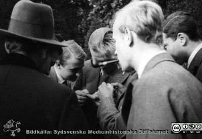 Fotoalbum  "Kursen i histologi H T 1932
Fotoalbum  "Kursen i histologi H T 1932".  Bildtext "Korten studeras". Troligen medicine studerande som tittar på dittills tagna kursfotografier, kanske utanför anatomiska institutionens huvudingång.  
Bildkälla stiftelsen Locus Medicus Lundensis och Sydsvenska Medicinhistoriska Sällskapet / SMHS. Fotograf okänd.
Nyckelord: Universitetet i Lund;Locus Medicus Lundensis;Anatomiska Institutionen;Histologiska avdelningen;Sydsvenska Medicinhistoriska Sällskapet;SMHS;Medicine studerande